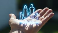 Glowing holographic family figures floating above open palm representing life insurance protection and financial security for loved ones.