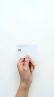 Hand holding white premium access credit card with chip on clean white background for financial and banking concepts.
