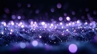 Purple and blue glowing bokeh lights create magical abstract background with blurred sparkles and shimmering particles floating in dark space.