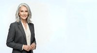 Middle-aged woman with gray hair wearing dark blazer and white shirt, isolated on white background for corporate and business design use.