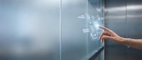 Hand pressing elevator button panel in modern office building with stainless steel interior and soft lighting for business and transportation concepts.