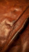 Rich brown leather texture with detailed stitching and natural grain patterns. Luxury material surface for fashion and craftsmanship projects.