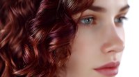 Young woman with auburn curly hair and blue eyes in profile view against light background, natural makeup and soft lighting creates romantic beauty portrait.