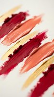 Abstract makeup brush strokes in warm autumn colors with gold accents on white background for cosmetic and beauty design projects.