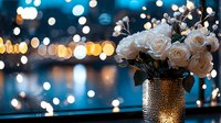 White roses in textured metallic vase against blurred bokeh lights background creating romantic evening atmosphere with warm golden and blue tones.