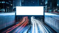 Large blank billboard above urban highway tunnel with colorful light trails from passing vehicles at night in modern city downtown area.
