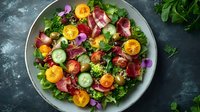 Fresh garden salad with mixed greens, sliced citrus, cucumber, radish, and edible flowers arranged on white plate for healthy eating and nutrition concepts.