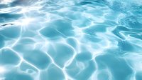 Mesmerizing turquoise water surface with sunlight creating rippling patterns and reflections, showing transparent aqua waves and natural light caustics.