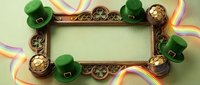 Ornate bronze frame with green leprechaun hats, gold coins, and rainbow ribbons on pale background, isolated for St. Patrick's Day designs, greeting cards, and festive marketing materials.