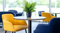 Modern cafe interior with yellow and navy blue armchairs around white round table decorated with potted fern plant, contemporary restaurant design.