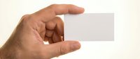 Male hand holding blank white business card mockup isolated on light background for branding and corporate identity design projects.