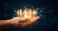 Hand holding glowing paper cutout people figures representing teamwork, unity and human connection for business and social concepts.