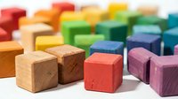 Colorful wooden toy blocks in rainbow spectrum arranged for educational play and creative building activities. Natural wood texture cubes for children development.