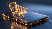 Glowing miniature shopping cart on smartphone with festive lights creating magical online shopping atmosphere against dark background.