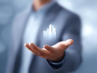 Professional businessman in suit displaying glowing financial chart hologram floating above palm, representing business growth and data visualization technology.