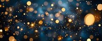 Magical glowing golden bokeh lights and sparkles scattered on dark blue background, creating dreamy festive atmosphere. Abstract defocused panoramic design.