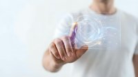 Person touching futuristic holographic interface with glowing circular elements and digital data visualization for technology and innovation concepts.
