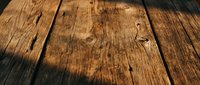 Rustic weathered wooden planks with natural grain texture and warm brown tones for backgrounds, flooring displays, and product photography applications.