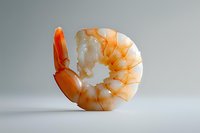 Fresh cooked shrimp on light background with soft shadow, close up view of single peeled prawn showing texture and detail in minimalist composition.
