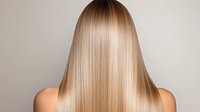 Young Caucasian woman with long straight blonde hair shown from behind on neutral background, demonstrating healthy, shiny hair texture for beauty and haircare advertising.