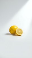 Fresh yellow lemon whole and half slice on clean white background with natural shadow lighting for healthy food and citrus fruit concepts.