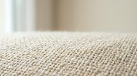 Close-up of beige carpet texture with soft focus background showing natural fiber weave pattern for interior design and home decor applications.