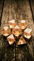 Copper polyhedral dice set on rustic wooden surface for tabletop gaming and role-playing adventures.