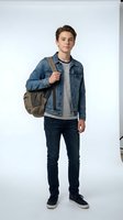 Young male student, Caucasian ethnicity, wearing denim jacket over striped shirt with dark jeans and canvas sneakers, carrying brown backpack on white background for education and lifestyle use.