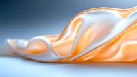 Smooth flowing fabric in peach and white creates elegant waves and folds against blue background, showcasing soft textile movement and luxurious satin texture.