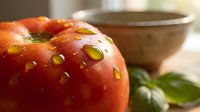 Fresh ripe tomato with glistening water drops, basil leaves, and ceramic bowl in soft natural light, evoking healthy organic cooking.