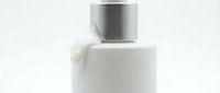 White cosmetic bottle with metallic silver cap on isolated background, ready for skincare, lotion, or beauty product packaging design and branding mockups.