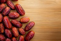 Fresh red dates scattered on wooden background with copy space, natural dried fruit snack for healthy eating and traditional medicine.
