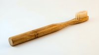 Natural bamboo toothbrush with soft bristles isolated on white background for eco-friendly dental care and sustainable oral hygiene products.