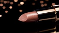 Luxurious metallic rose gold lipstick close-up on black background with bokeh lights, showcasing cosmetic product detail and shimmer texture for beauty advertising.