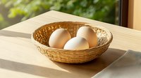 Fresh white chicken eggs in woven bamboo basket on wooden table with natural sunlight casting soft shadows, rustic farmhouse style composition.
