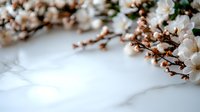Delicate white cherry blossoms on branches against soft blurred background, creating dreamy spring atmosphere with gentle bokeh effect and copy space.