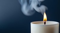 Burning white candle with bright flame and wispy smoke against dark blue background creating peaceful ambiance for relaxation and meditation.
