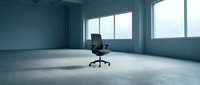 Empty modern office space with single black executive chair on concrete floor, large windows with natural light, minimalist workspace for business, corporate environment, and professional settings.