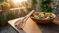 Fresh mixed salad with colorful vegetables in wooden bowl on rustic outdoor table with natural sunlight streaming through garden setting.