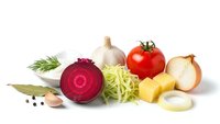 Fresh organic vegetables isolated on white background including sliced beetroot, cabbage, tomato, garlic, onion and herbs for healthy cooking and meal preparation.