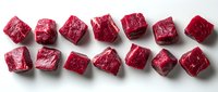 Raw beef cubes arranged in row on white background, fresh red meat chunks showing marbling and texture, ready for cooking preparation.