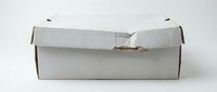 White cardboard shipping box with torn corner damage isolated on light background for packaging and delivery concepts.