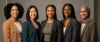Group of five diverse women professionals standing together in business casual attire, representing teamwork, diversity, and corporate collaboration in modern workplace settings.