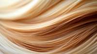 Smooth flowing waves of blonde and caramel hair strands create elegant curves and lines against light background, showcasing natural hair texture and movement.