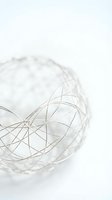 Modern wire mesh sphere on white background showcasing geometric patterns and metallic finish for contemporary design projects.