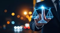 Businessman holding glowing digital scales of justice with holographic light effects against blurred city lights background for legal technology concepts.
