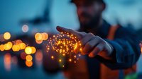 Young man holding glowing magical light particles in hands at dusk, creating ethereal bokeh effect against blurred city lights background. Artistic conceptual photography.