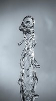 Water stream with splashing droplets and bubbles against neutral background, suitable for beverage, refreshment, and hydration marketing materials.