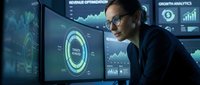 Professional businesswoman analyzing financial data on multiple computer monitors in modern office environment with digital analytics dashboards.