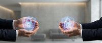 Two business professionals holding glowing digital security shield icons with padlock symbols representing cybersecurity protection and data safety solutions.
